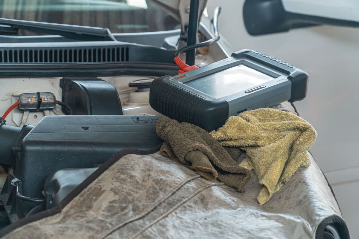 Technicien vérifiant l'autonomie batterie occasion avec un outil de diagnostic