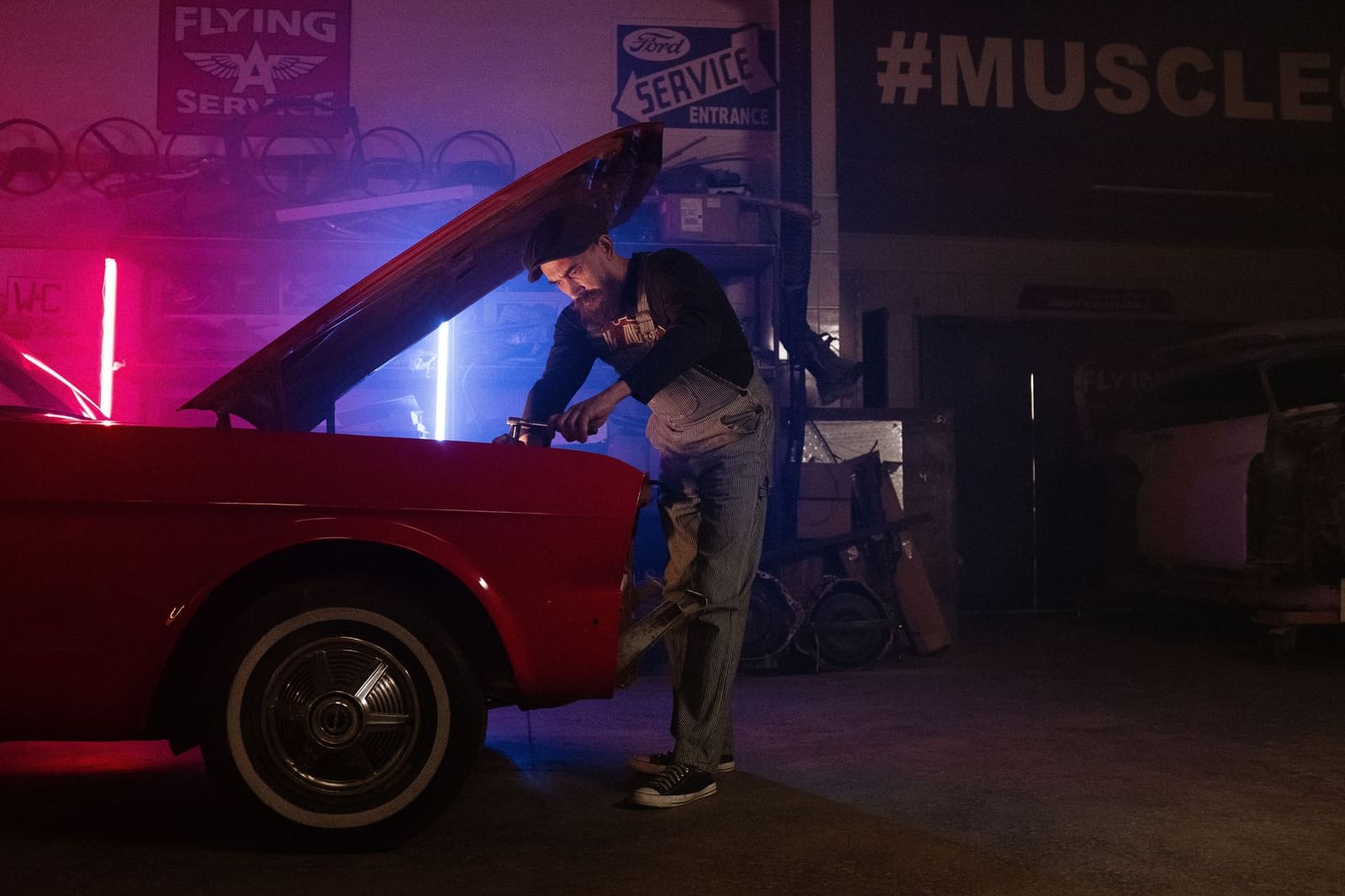 Passionné d'automobile examinant le moteur d'une voiture dans un atelier lumineux