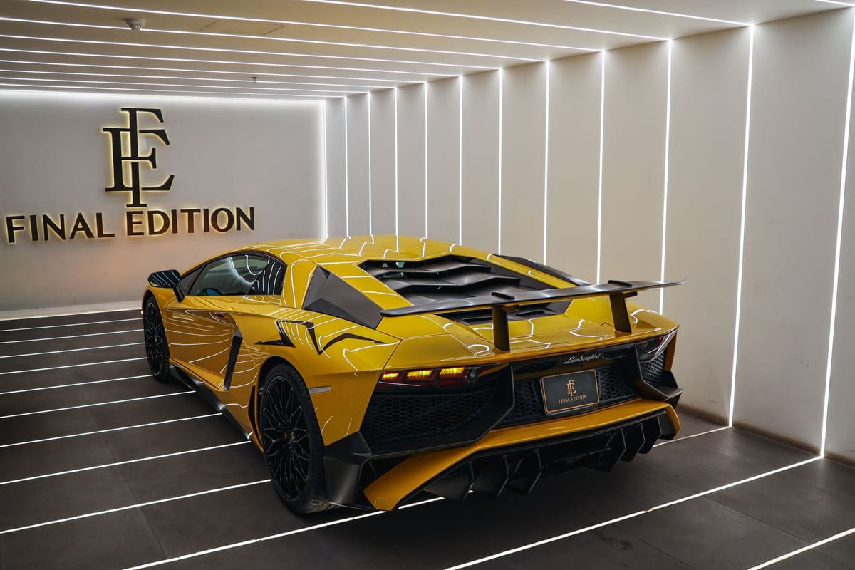 Plusieurs marques de voiture de luxe alignées dans un showroom lumineux